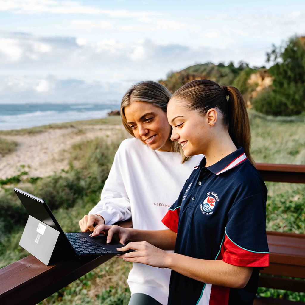Mother and Daughter on Computer together at beach. Virtual Learning