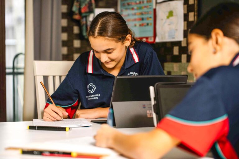 a virtual learning distance ed school student looks down at a page and writes in her book